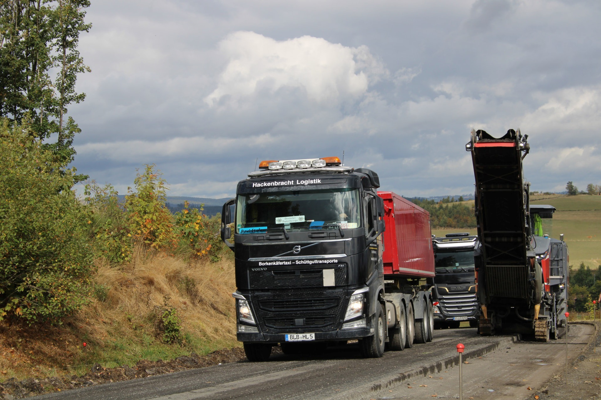 Volvo FH von Hackenbracht Logistik neben einer Straßenfräse auf der Baustelle