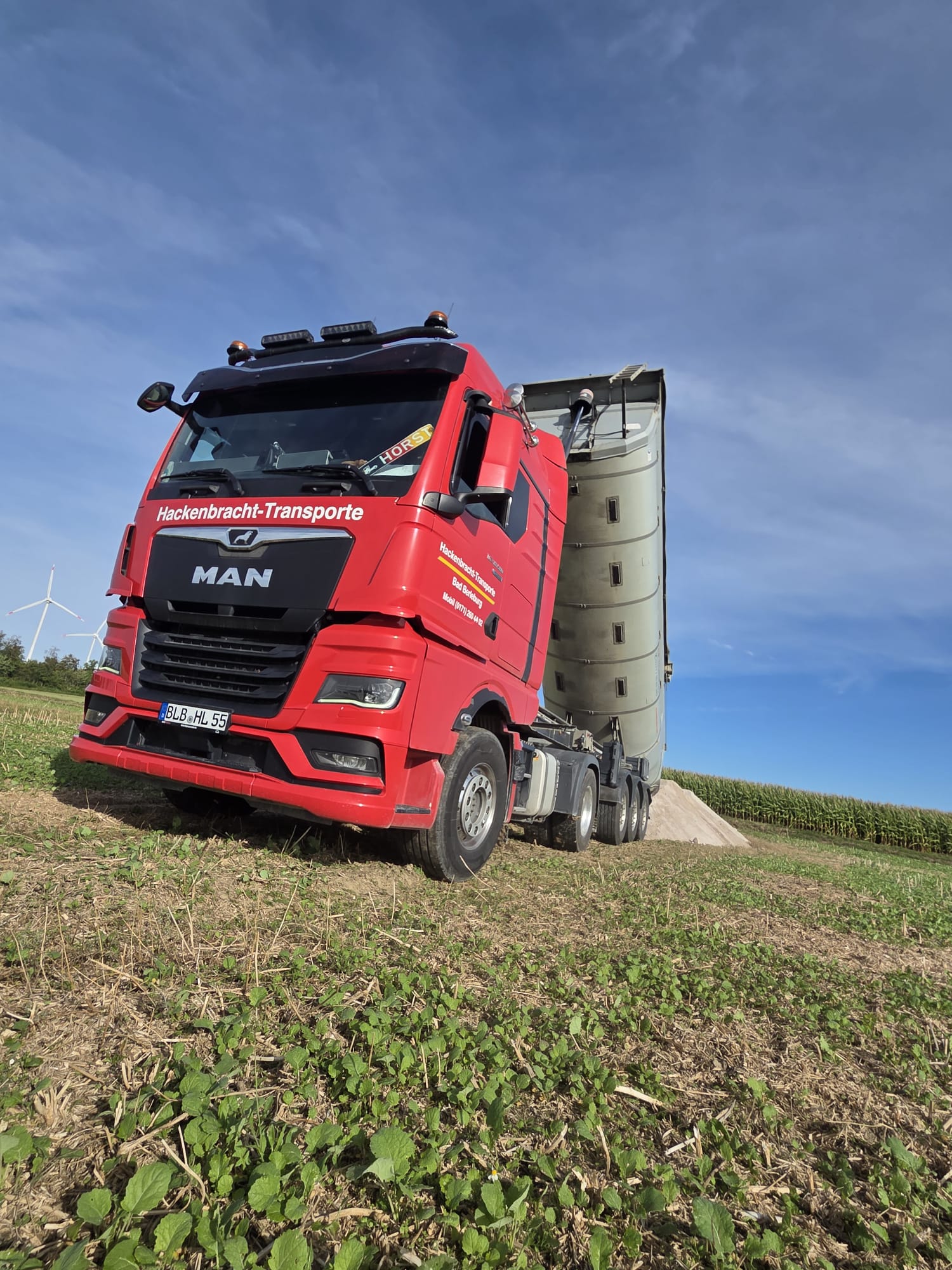 Roter MAN-LKW von Hackenbracht-Transporte mit Siloauflieger für Kalktransport